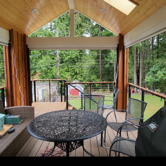 Covered patio with outdoor seating and forest view