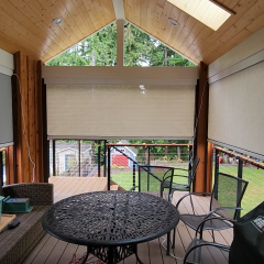 Enclosed patio with outdoor furniture and green view.
