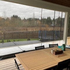 Patio with table overlooking backyard and trampoline.