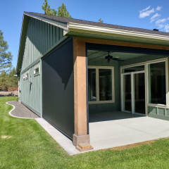 Green house with patio and forest background