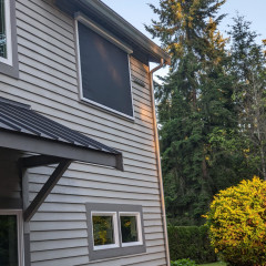 House with metal siding and surrounding greenery