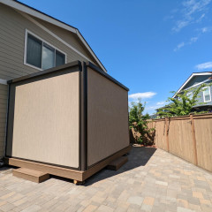 Backyard storage shed beside house with blue sky
