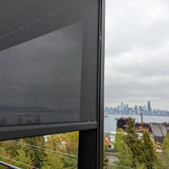 City skyline seen from a balcony with screen.