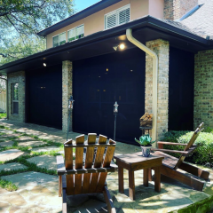 Sunny patio with wooden chairs outside brick house.