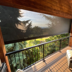 Shaded balcony with forest view at sunset.